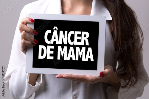 Female doctor holding a tablet with the text: Breast Cancer (in Portuguese)