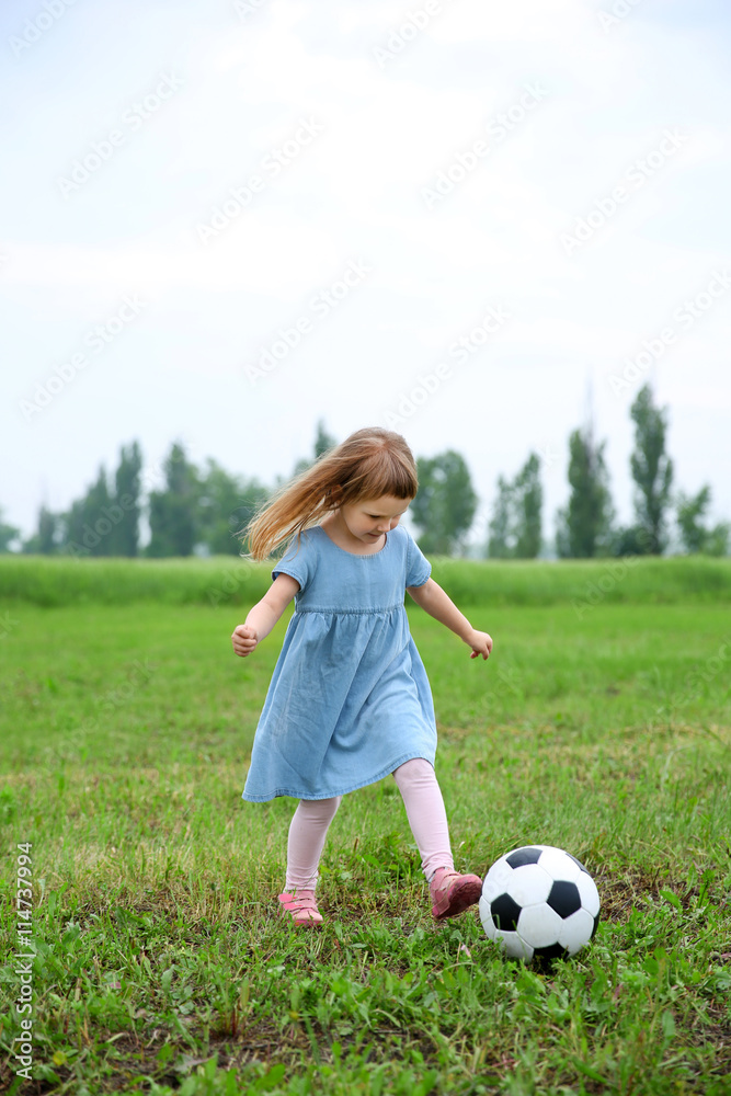 Little girl playing football outdoor