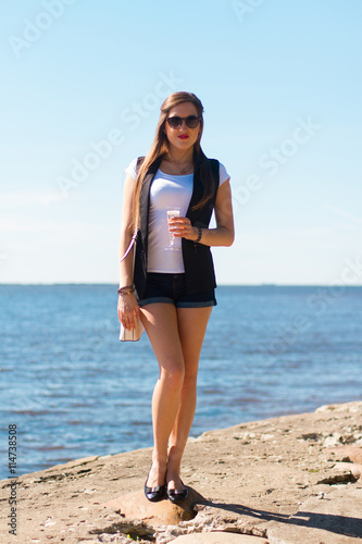Image of sexy woman posin on sea in glasses