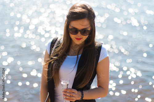 Image of sexy woman posin on sea with glass