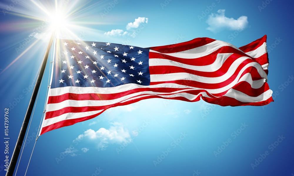 Obraz premium American flag in blue sky and sunshine background