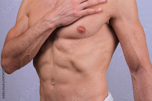 Male Waxing. Muscular torso  chest and armpit hair removal close up.