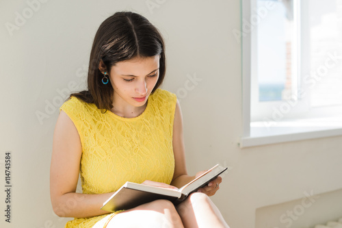 Female student preparing for exam. Teenager girl studying sitting on a rack home in the living room or at school library