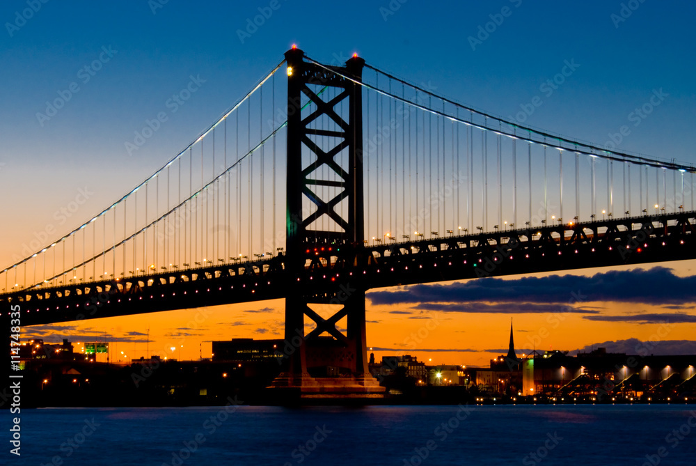 A Sunset View of The Benjamin Franklin Bridge, Philadelphia, Pennsylvania from the Delaware River. A Sunset View of The Benjamin Franklin Bridge, Philadelphia, Pennsylvania from the Delaware River.