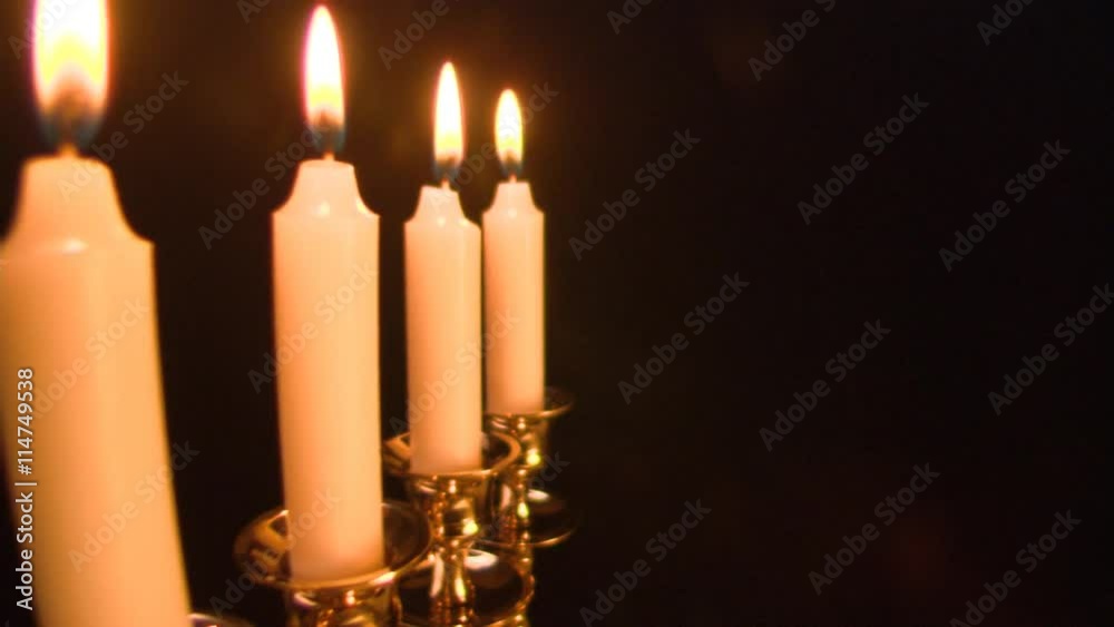 Menorah coming into frame, man's hand lighting candles and placing central one; full view of Menorah Menorah coming into frame, man's hand lighting candles and placing central one; full view of Menorah