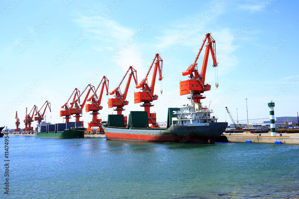 In freight terminal, gantry crane and cargo ships are in loading In freight terminal, gantry crane and cargo ships are in loading