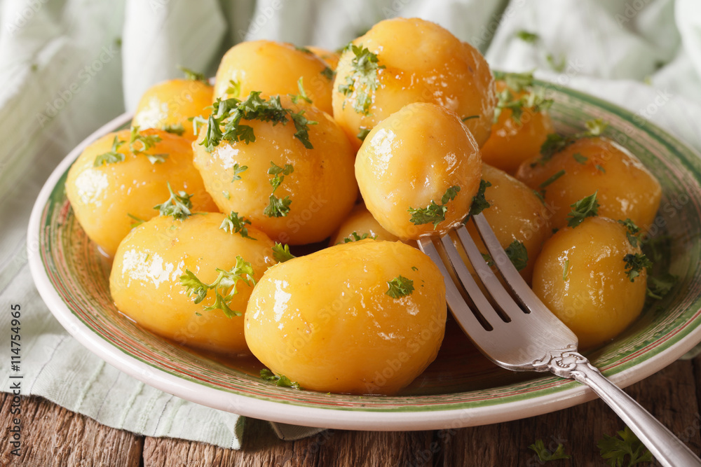 Homemade caramelized new potatoes close-up on a plate.
Homemade caramelized new potatoes close-up on a plate.