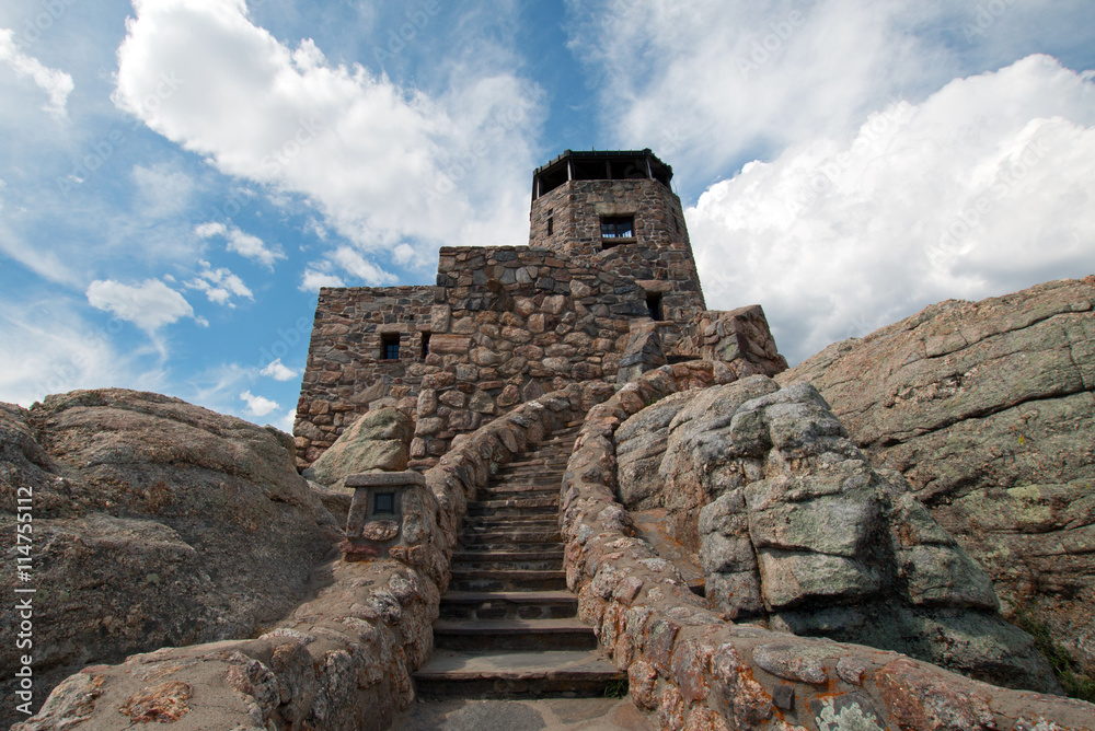 Harney Peak Fire Lookout Tower under cumulus cloudscape in Custer State Park in the Black Hills of South Dakota USA