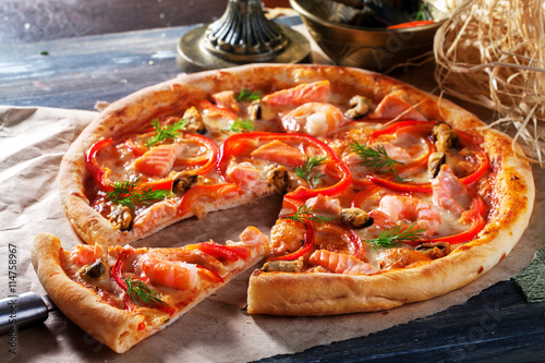 Pizza with salmon mussels, shrimp dill, close-up, sweet pepper