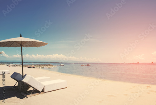 Holiday vacation at the beach, Beach deck chairs with parasol on tranquil beach, vintage tone soft focus