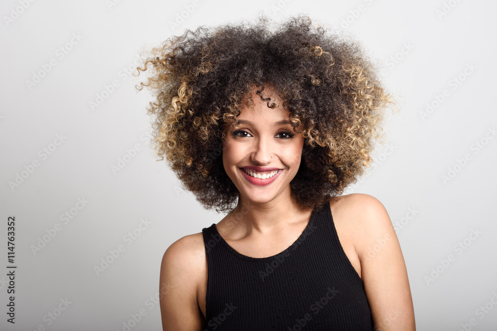 Young black woman with afro hairstyle smiling Young black woman with afro hairstyle smiling