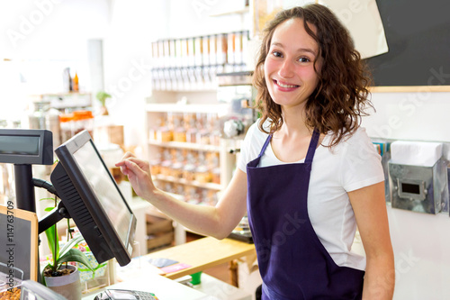 Fotografie Young attractive woman working at the grocery store