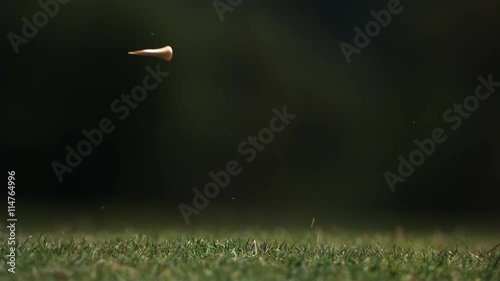 Close-up of golf ball on tee and club head striking it in ultra-slow motion