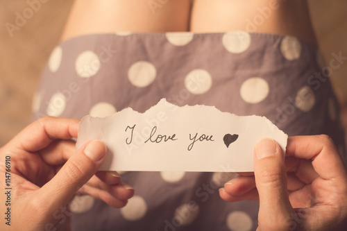 Konstfotografi Woman holding a paper note with the text I love you