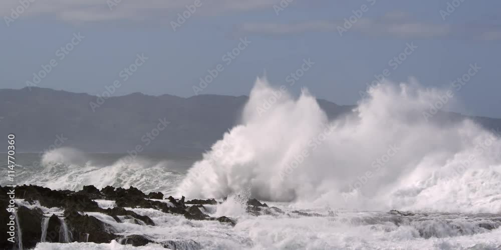 Breaking waves obscuring the Hawaiian coastal hills in the background Breaking waves obscuring the Hawaiian coastal hills in the background