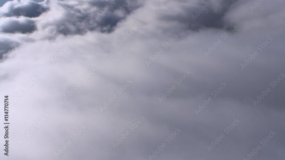 Flight looking back at receding dense clouds, passenger POV Flight looking back at receding dense clouds, passenger POV