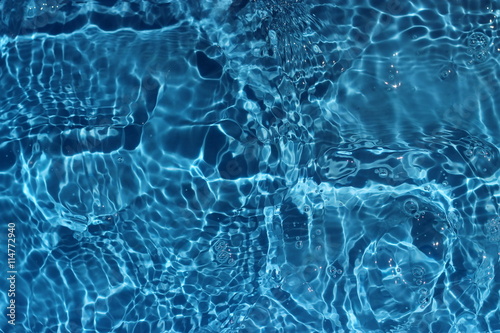 Sun reflections in blue pool water from above