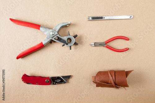 Working tools for embossed leather on brown background top view