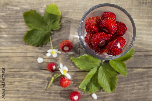 berries and leaves of wild strawberry on background of old wooden planks
