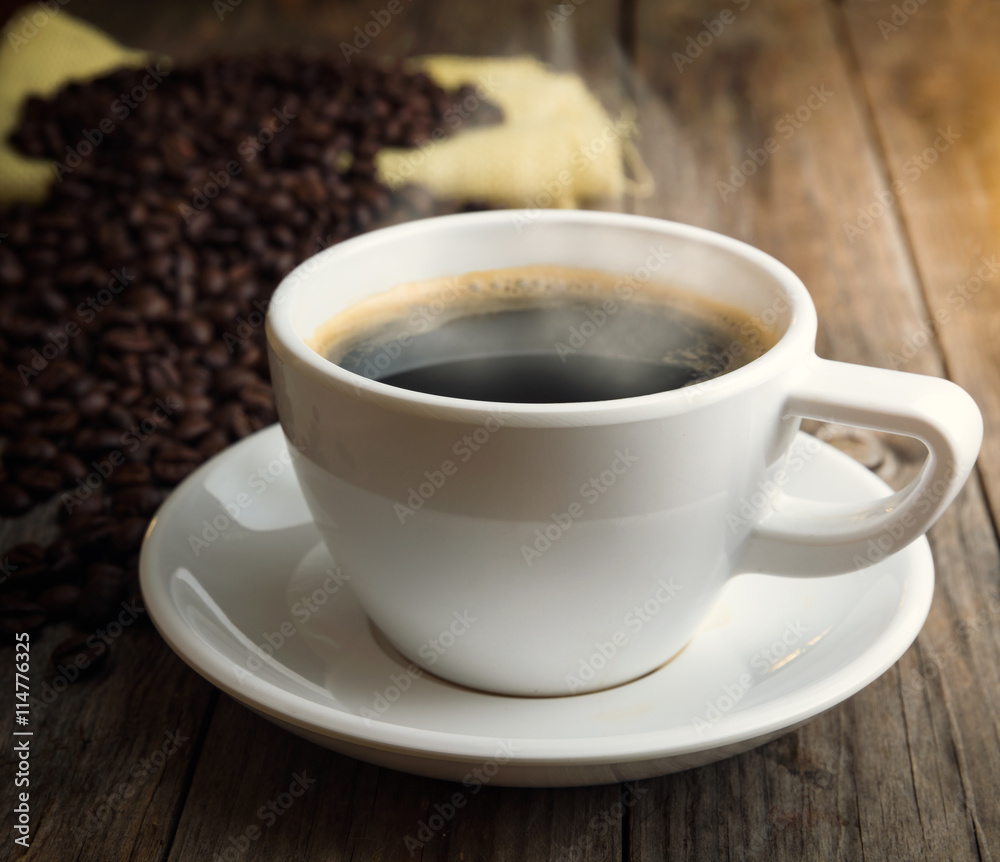 Closeup coffee cup and beans on wooden table