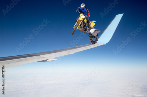 Fototapeta Naklejka Na Ścianę i Meble -  Motorradfahrer auf Flugzeug-Tragfläche