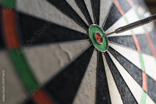 Single dart hitting bull's eye on the dartboard