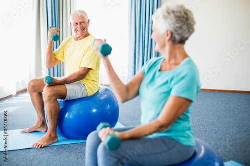 Seniors using exercise ball and weights