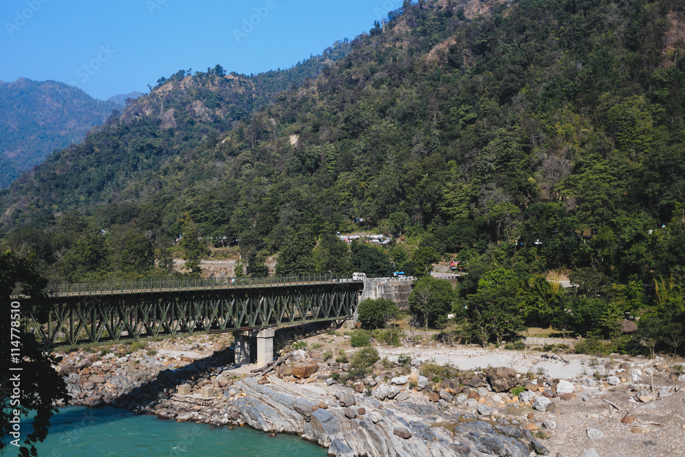 Naklejka premium Bridge over the Ganga, walking around Rishikesh, holy Indian pla