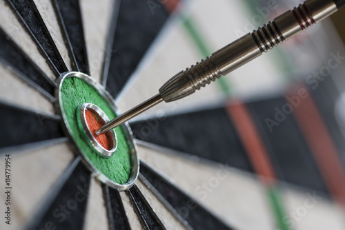 Single dart hitting bull's eye on the dartboard