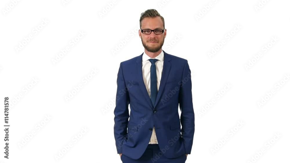 A trendy man wearing a blue suit, white shirt and blue tie with glasses. Standing in front of a white background looking at camera. A trendy man wearing a blue suit, white shirt and blue tie with glasses. Standing in front of a white background looking at camera.