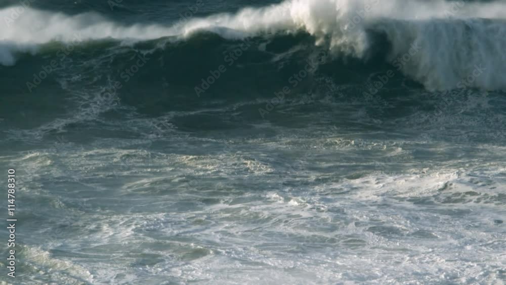 A foaming breaker rushes in to smother in turbulent surf