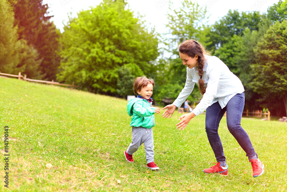 Young mother running with little boy on sunny day in the park. Happy woman and adorable toddler child having fun. Motherhood and childhood concept, positive human emotions, feelings. Young mother running with little boy on sunny day in the park. Happy woman and adorable toddler child having fun. Motherhood and childhood concept, positive human emotions, feelings.
