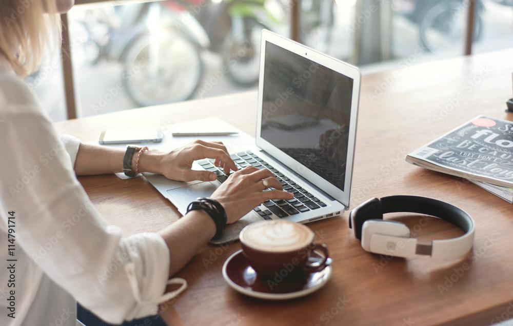 Young woman freelancer working with laptop in cafe