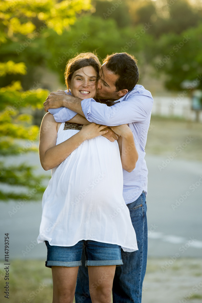 Obraz premium happy couple in love together in park landscape on sunset with woman pregnant belly and man
