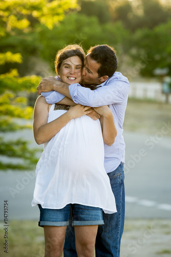 happy couple in love together in park landscape on sunset with woman pregnant belly and man