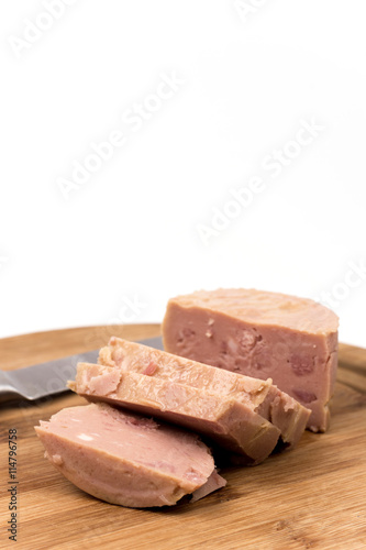 Luncheon meat on the wooden board isolated on white background
