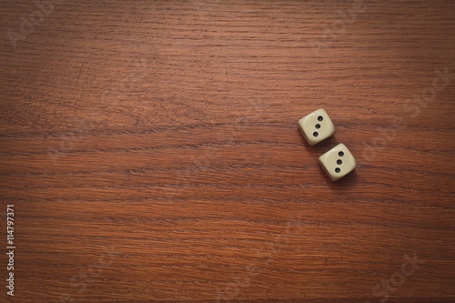 two dice on a wooden table value of three