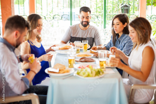 Group of friends eating hamburgers outdoors