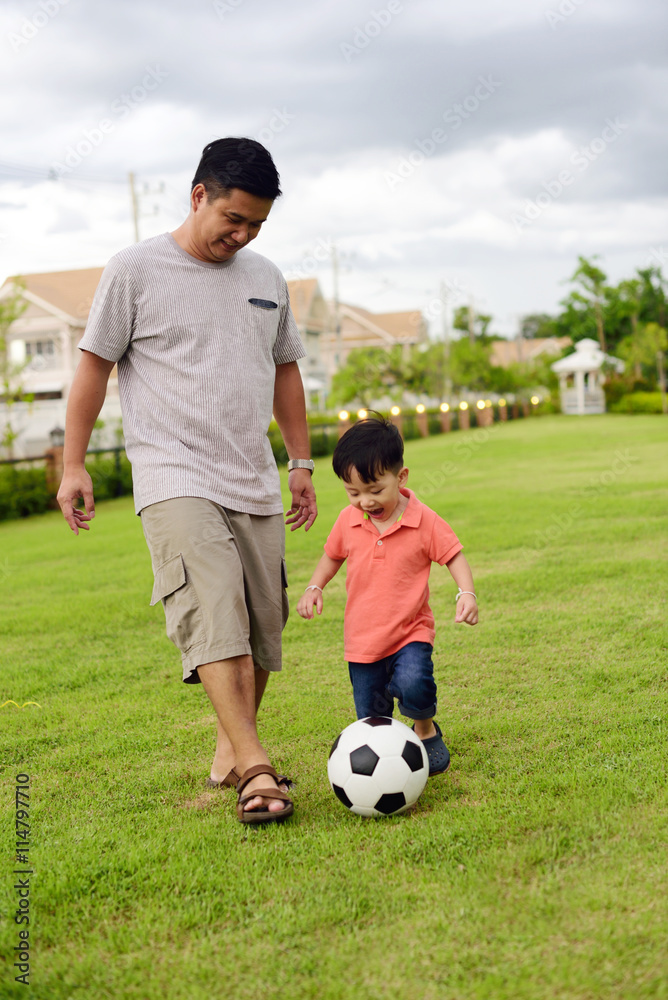 Asian boy play football with his father in the garden
Asian boy play football with his father in the garden