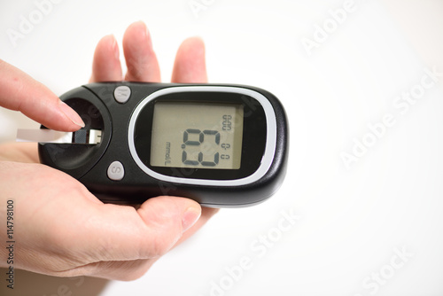 First type Diabetes patient measuring glucose level blood test use glucometer and small drop of blood from finger and test strips