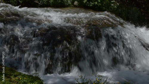 Close-up of an overfall of fast mountain river photo