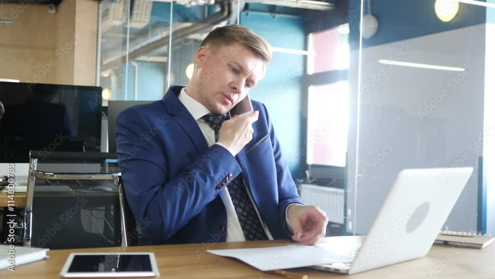businessman doing multitasking , working with documents , laptop and phone businessman doing multitasking , working with documents , laptop and phone