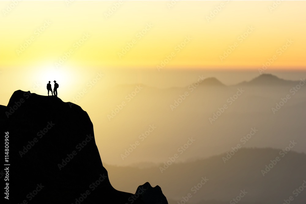 Two people silhouette of happy couple stand together on peak of