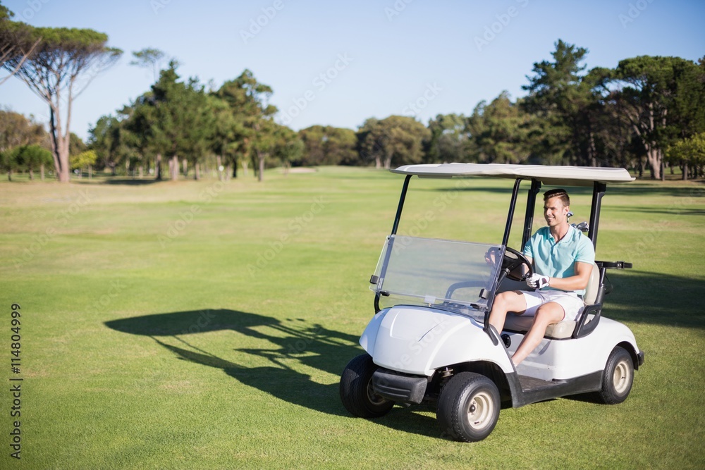 Full length of happy golfer man driving golf buggy Full length of happy golfer man driving golf buggy