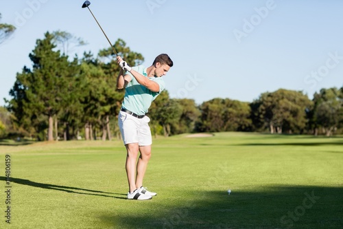 Concentrated golfer man taking shot 