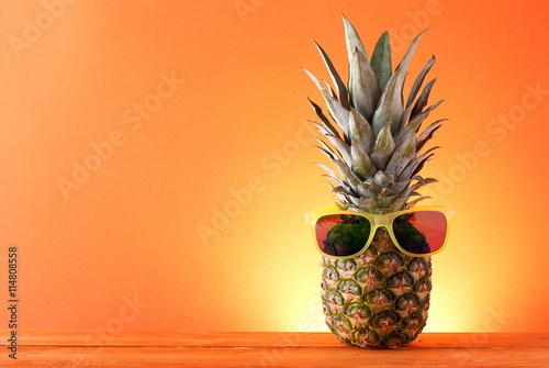Pineapple in sunglasses on a bright background