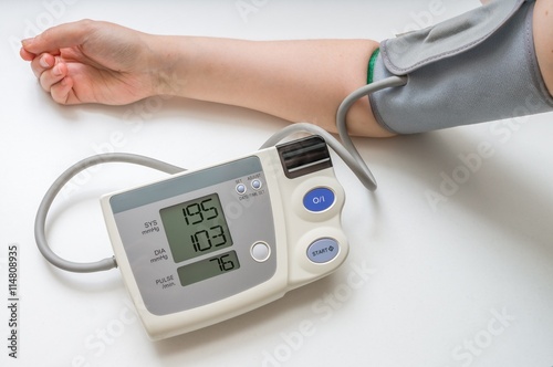 Hypertension concept. Man is measuring blood pressure with monitor.