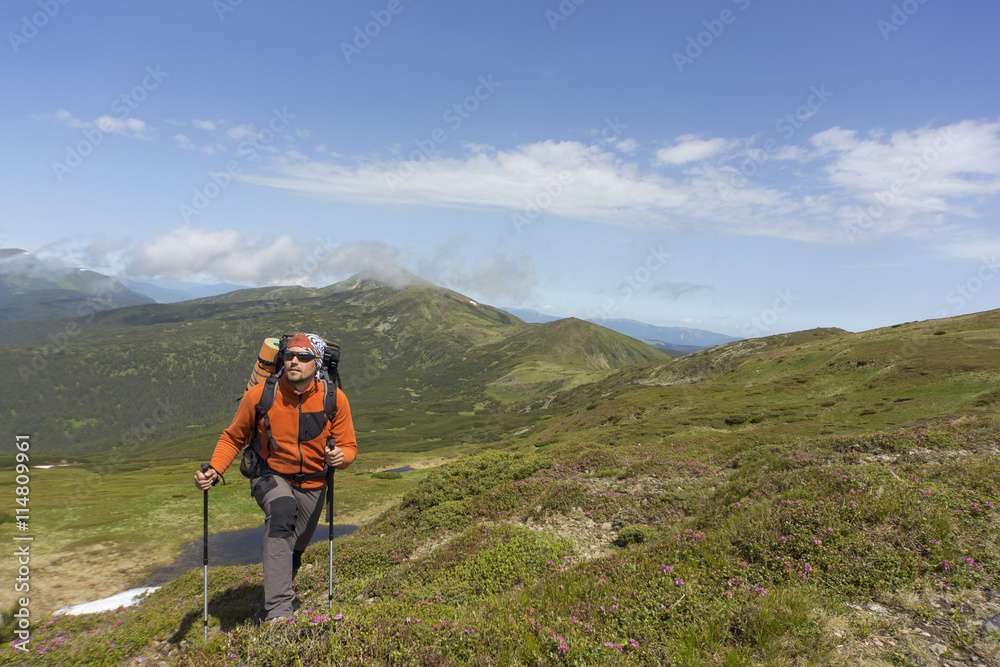 Summer hiking in the mountains with a backpack . Summer hiking in the mountains with a backpack .