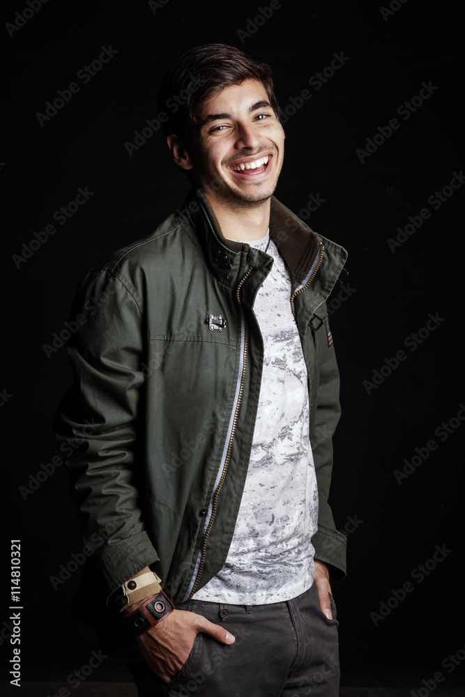 Fototapeta premium Joven moreno sonriendo con las manos en los bolsillos