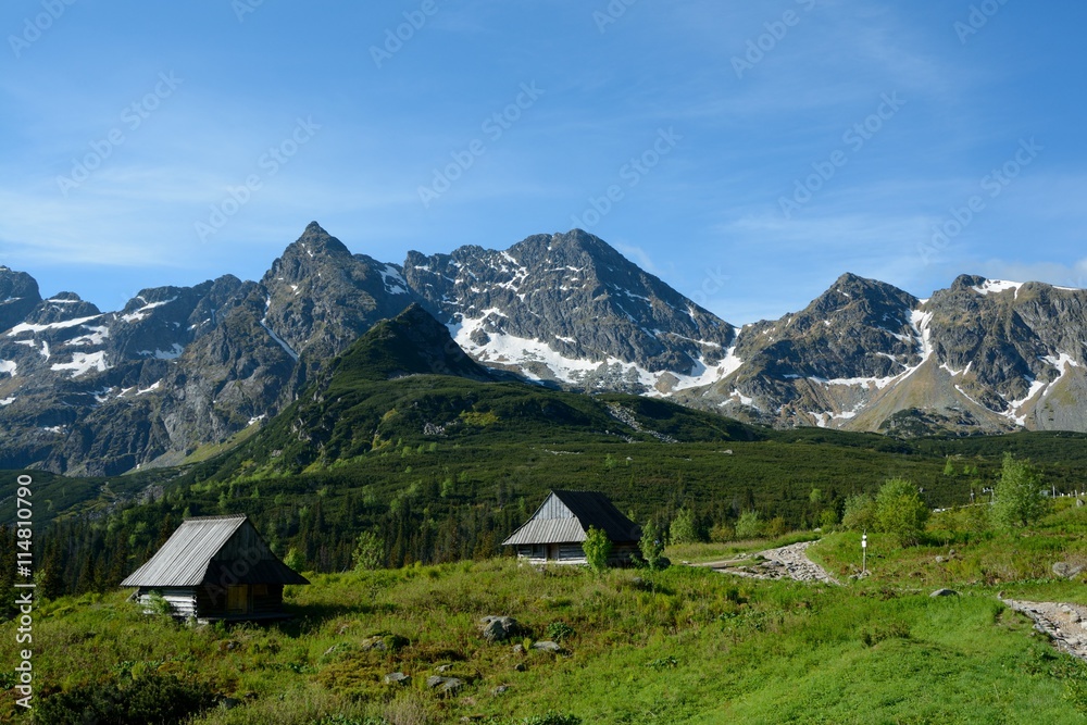 Two old wooden small huts and peaks in Gasienicowa valley